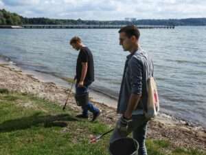 Nils und Marcel sammeln am Brodaer Strand Müll auf.