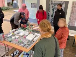 Bürger*innen sammeln an einem Modell Ideen für die Umgestaltung des Rathausumfeldes in Neubrandenburg.
